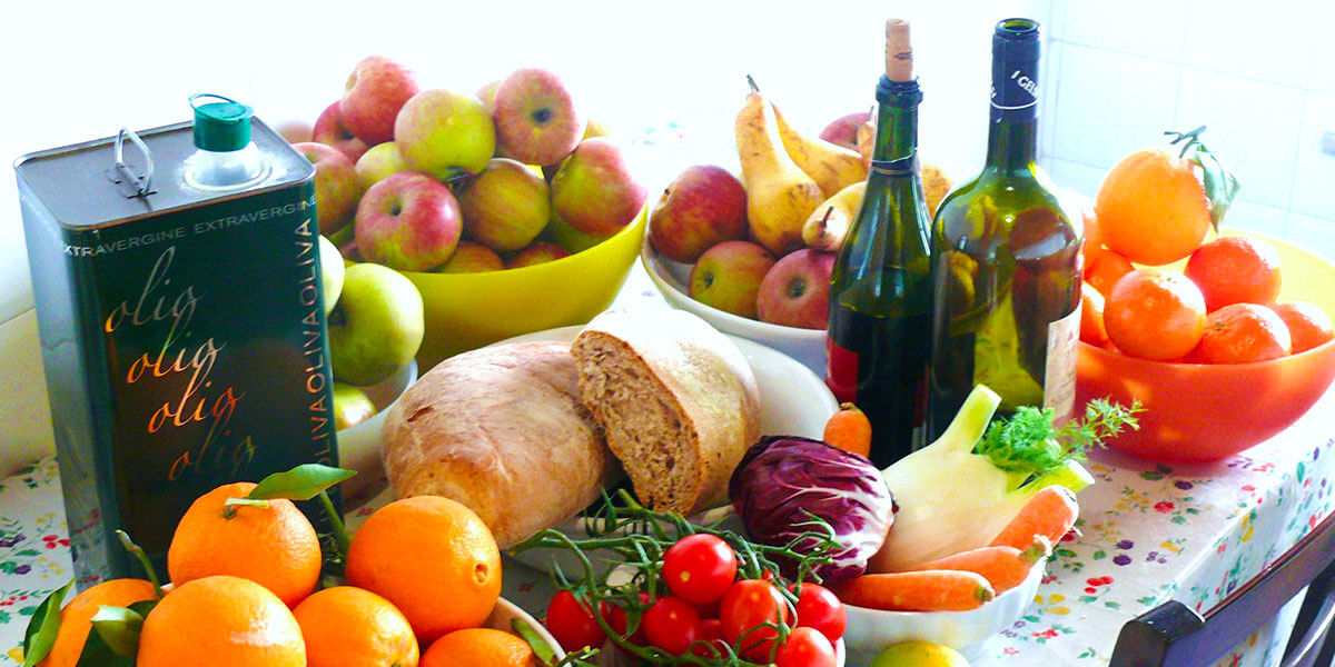 Foto che raffigura una tavola con degli alimenti tipici della dieta mediterranea
